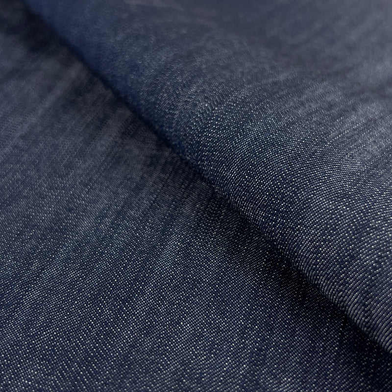 Close-up of dark indigo 100% tencel denim fabric with a subtle sheen