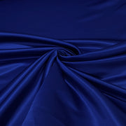 A close-up of draped royal blue satin fabric with a glossy sheen and soft folds.
