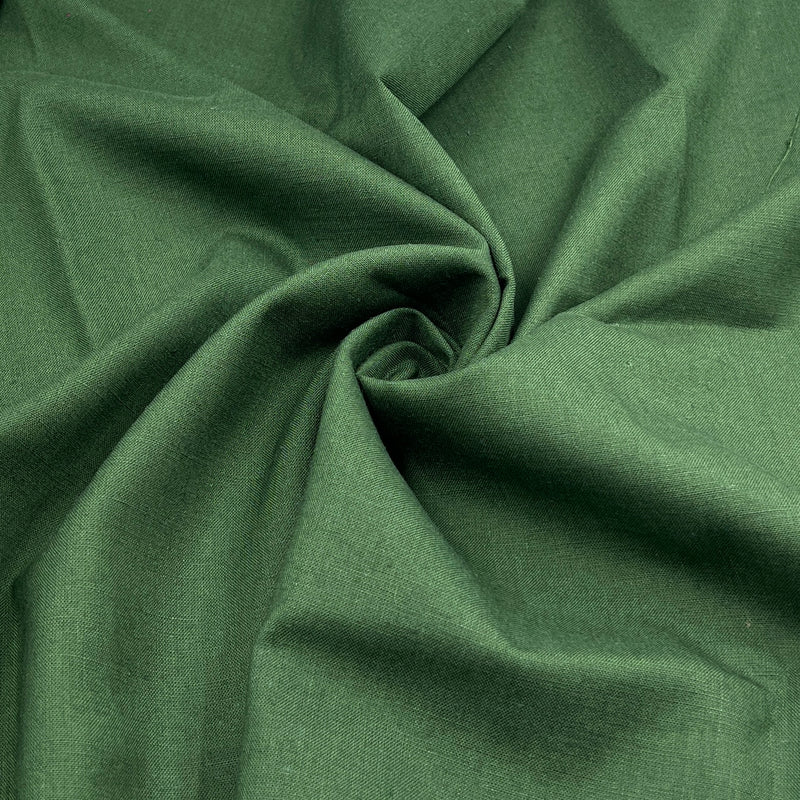 A close-up of dark green linen fabric with a textured weave, arranged in a spiral drape to show its texture and color.