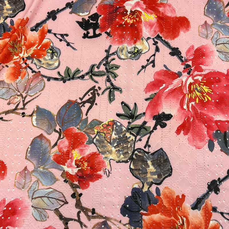 A close-up of a pink patterned fabric or wallpaper featuring watercolor-style red and orange flowers with green and gray-blue leaves on black branches.