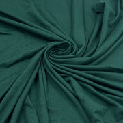Dark teal green fabric draped in a spiral pattern, showing its soft texture and drape.