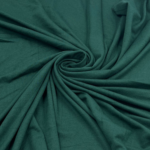 Dark teal green fabric draped in a spiral pattern, showing its soft texture and drape.