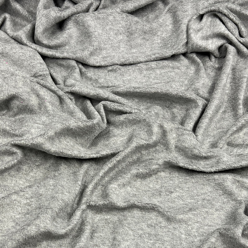 A close-up of draped heather gray fabric with soft folds and a textured, plush surface.