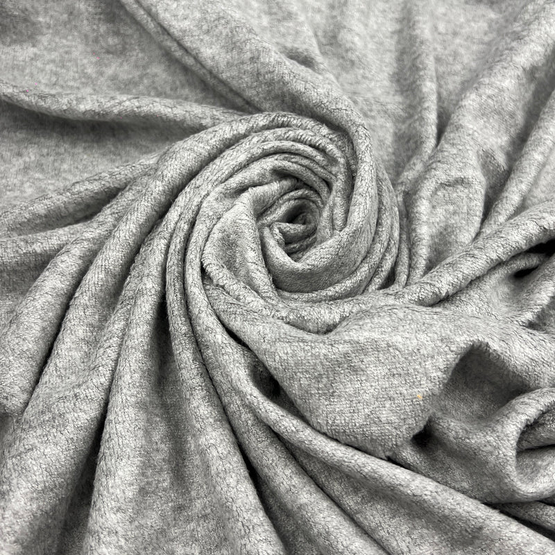 A close-up of light gray heathered fabric arranged in a spiral drape, showing the soft texture and weave of the material.