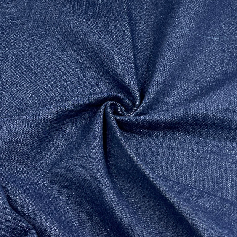 A close-up of dark blue denim fabric with a textured twill weave, arranged in a spiral drape to show its texture and color.