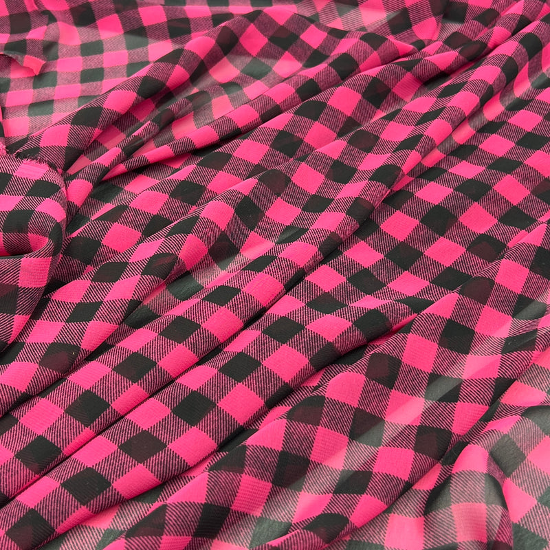 Chiffon fabric with a hot pink checkered pattern draped over a white background.