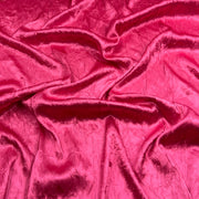 Bright pink crinkled fabric with a shiny, textured surface, shown draped in soft folds.