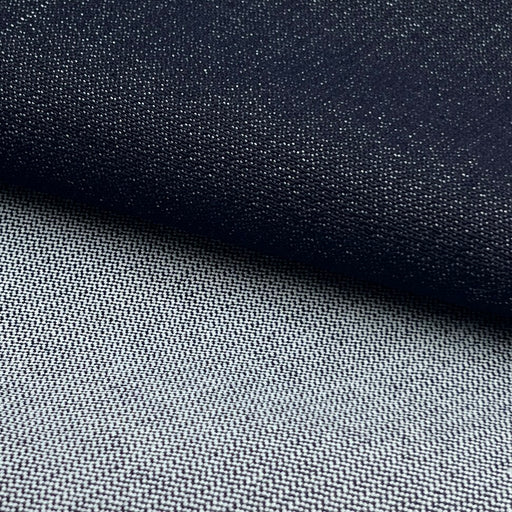 Close-up of a woven fabric texture in two tones: a dark navy section on top and a lighter gray section below, with a diagonal fold separating them.