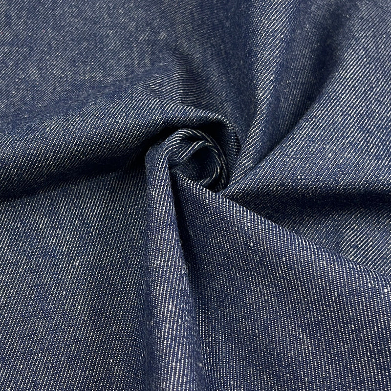 A close-up of dark indigo denim fabric with a twisted center, showing the detailed twill weave texture.
