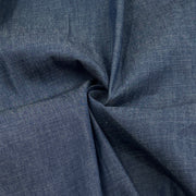 A close-up of dark blue textured fabric with a twisted fold in the center, showing the material's weave and color.