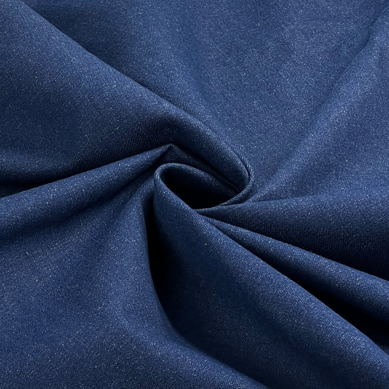 A close-up of dark blue fabric with a soft, textured weave, arranged in elegant folds and swirls.