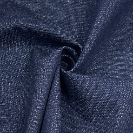 A close-up of dark navy blue fabric with a visible woven texture, arranged in soft folds and a central swirl.