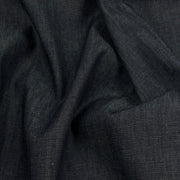 A close-up of dark charcoal gray fabric with a fine twill texture, shown in soft draped folds.