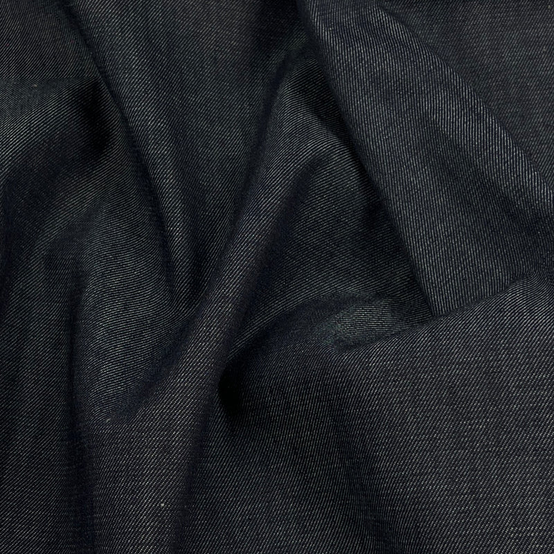 A close-up of dark charcoal gray fabric with a fine twill texture, shown in soft draped folds.