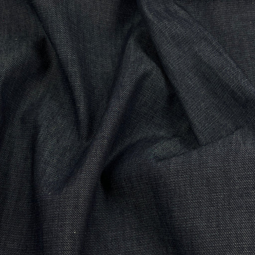 A close-up of dark charcoal gray fabric with a fine twill texture, shown in soft draped folds.