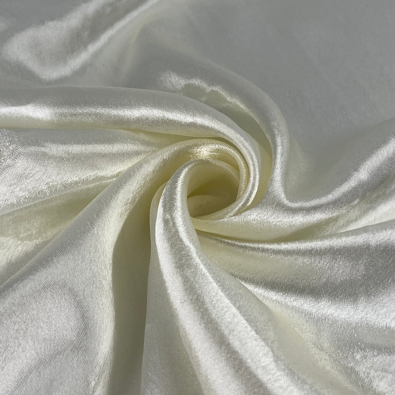Close-up of white satin fabric with folds