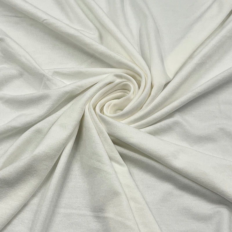 A close-up of off-white or cream-colored fabric arranged in a spiral drape, showing its soft texture and smooth surface.