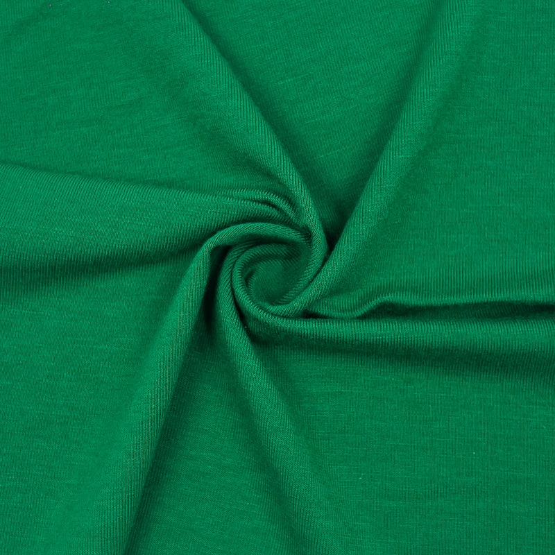 A close-up of bright green jersey fabric arranged in a spiral drape, showing the texture and color of the material.