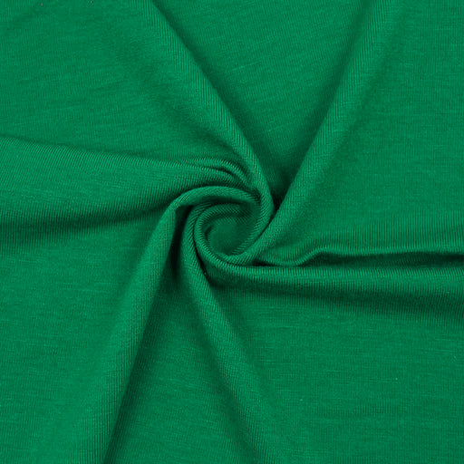 A close-up of bright green jersey fabric arranged in a spiral drape, showing the texture and color of the material.