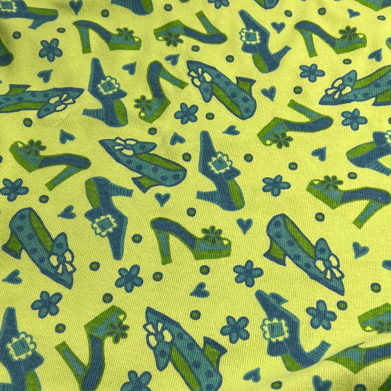Pattern of blue high-heeled shoes with flowers on a green background