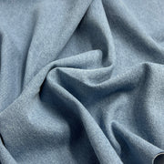Light blue washed denim bunched into a pile to show off pliable, soft texture