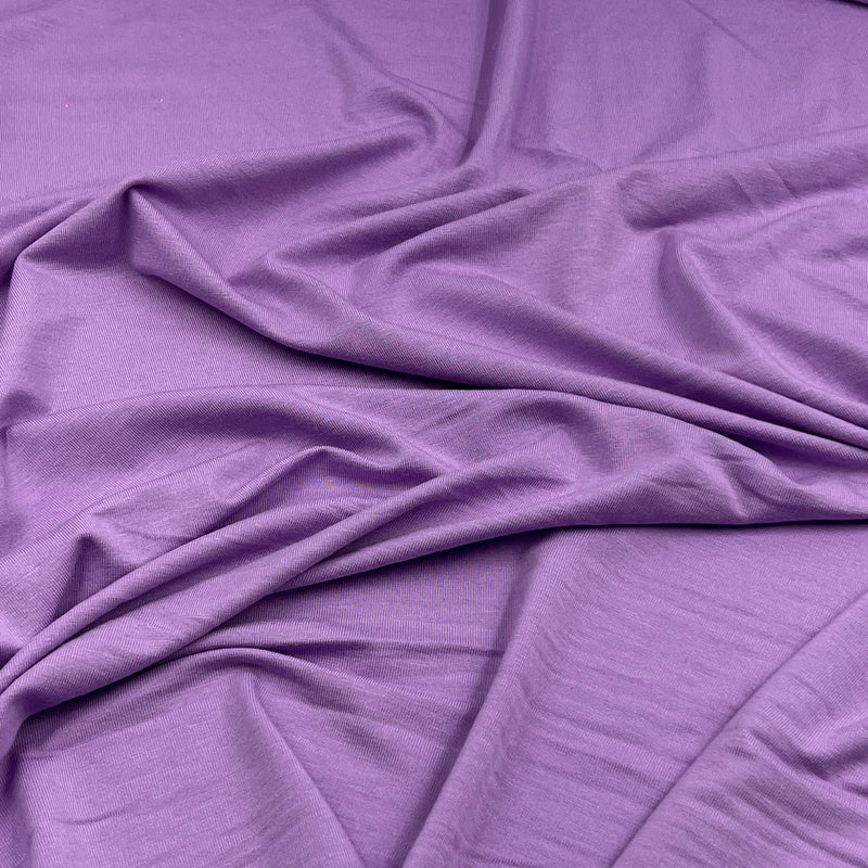 Purple fabric draped in soft folds, showing a smooth texture and matte finish.