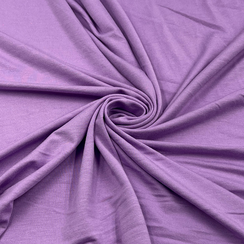 Purple fabric draped in a spiral pattern to show off its texture and drape.