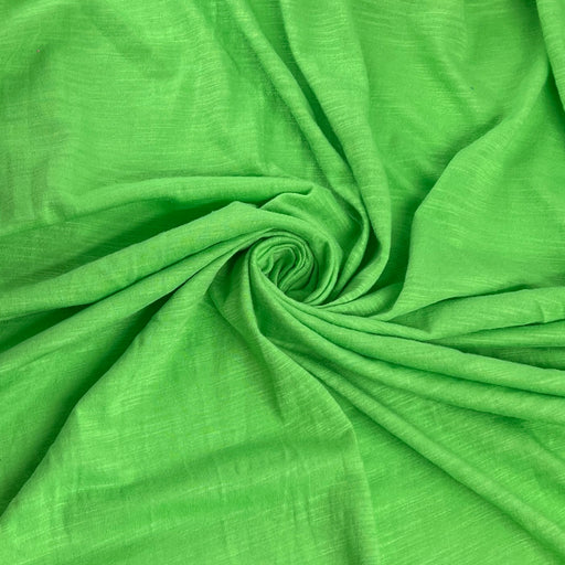 Bright green textured fabric draped in a spiral pattern, showing its woven slub texture.