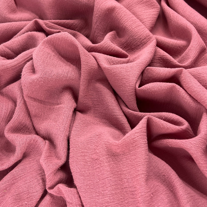 Lightweight 100% cotton bubble gauze in rich mauve pink color delicately ruffled into a pile showing off soft hand and drapeability