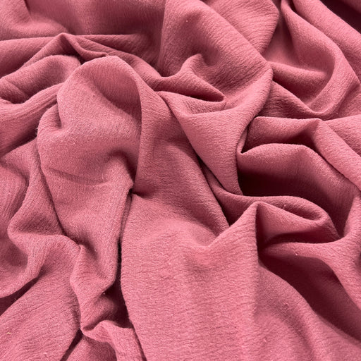 Lightweight 100% cotton bubble gauze in rich mauve pink color delicately ruffled into a pile showing off soft hand and drapeability