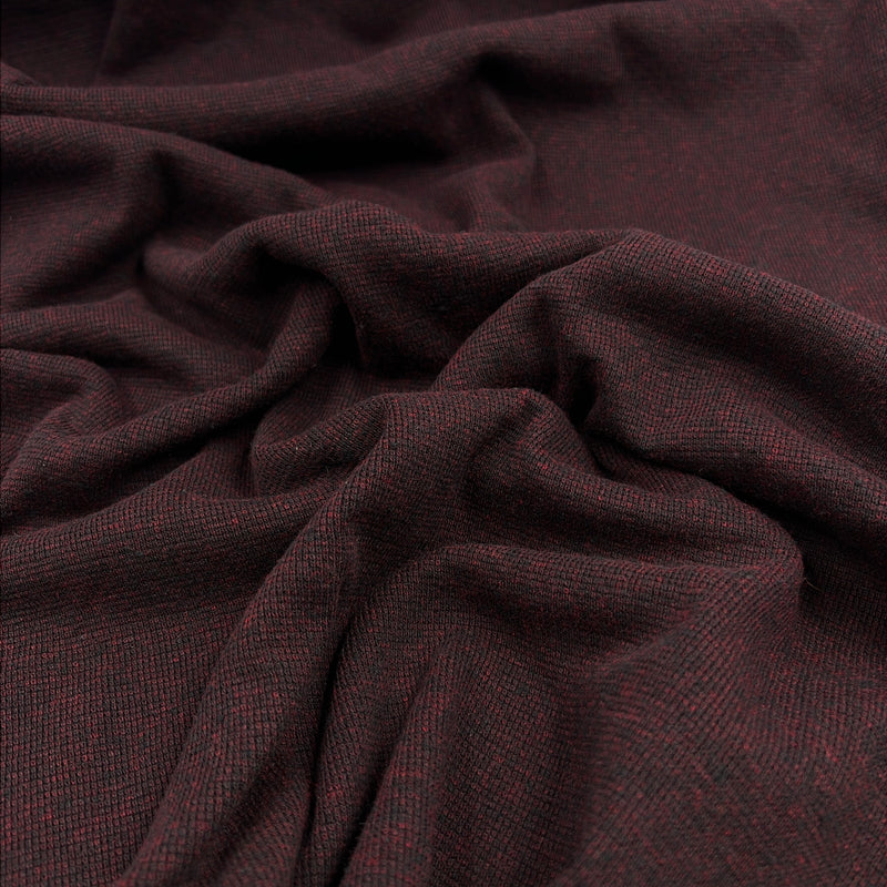 A close-up of draped fabric with a fine woven texture in a very dark burgundy-brown color, showing folds and the material's subtle heathering.