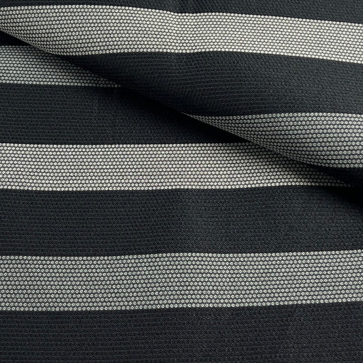 A close-up of a woven fabric with horizontal stripes in black and light gray, showing the texture and pattern details.