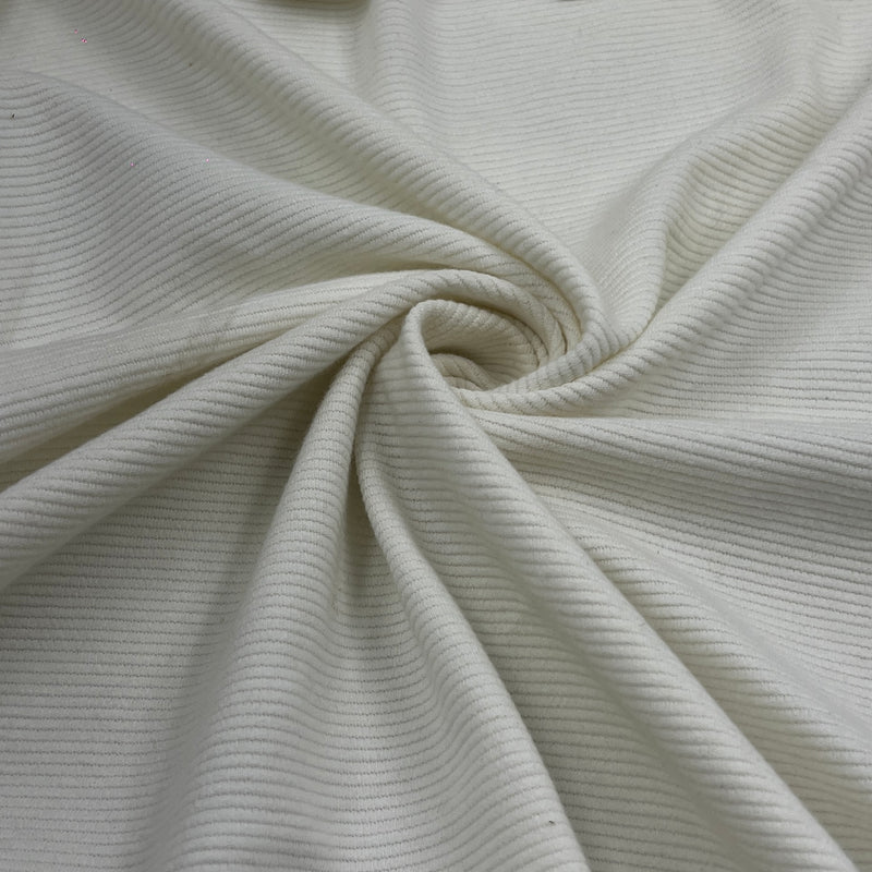 A close-up of off-white ribbed fabric, twisted into a spiral to show its texture and drape.