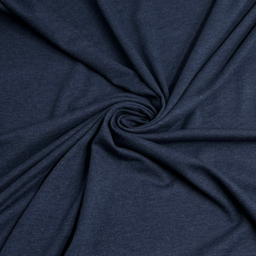 A close-up of dark navy blue heathered fabric arranged in a spiral drape, showing the material texture and color.