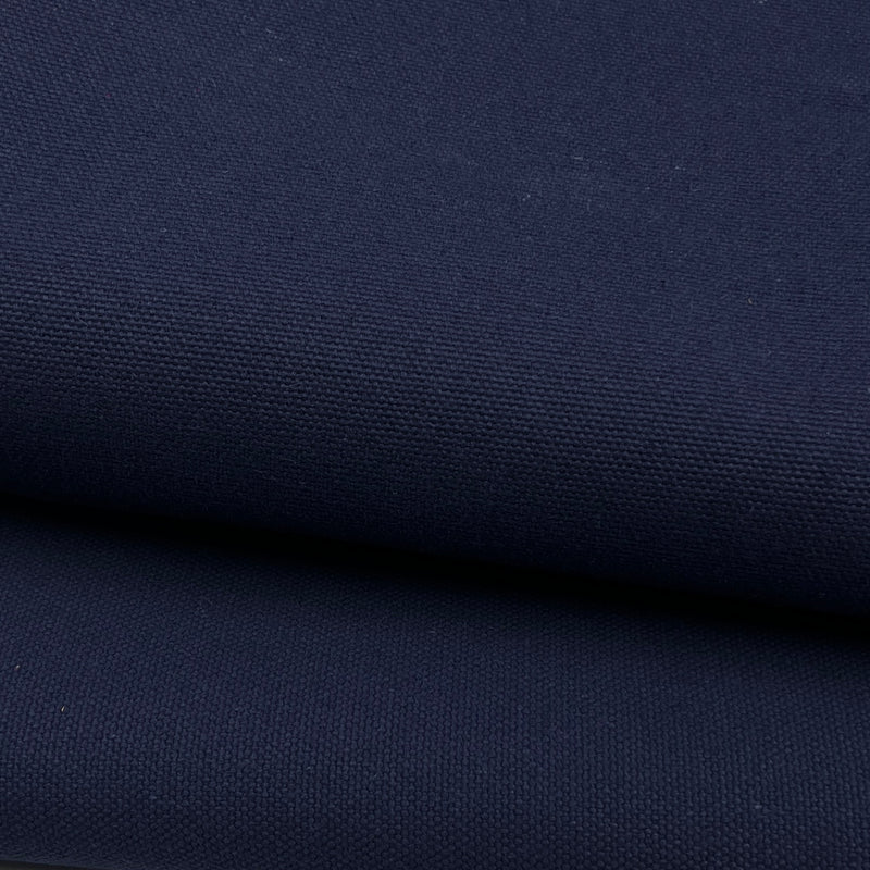 A close-up of dark navy blue canvas fabric with a visible woven texture, shown in two folded layers.