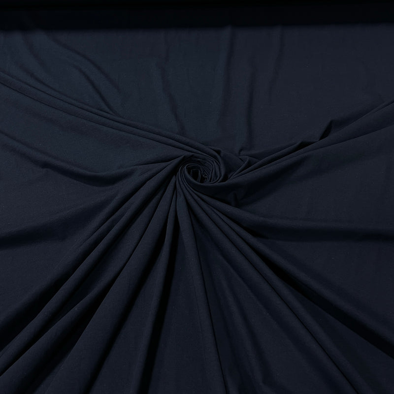 A close-up of dark navy blue fabric gathered in a spiral twist, showing the material's texture and drape.