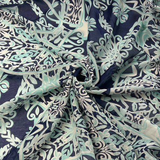 A lightweight sheer fabric with an intricate botanical damask pattern in navy blue, mint green, and cream, styled with a central swirl.