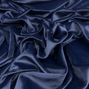 A close-up of draped navy blue velvet fabric with soft folds and a subtle sheen.