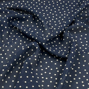 A close-up of draped navy blue fabric with a white polka dot pattern.