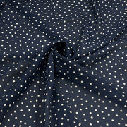 Navy blue fabric with a white polka dot pattern, shown with a central swirl to highlight the material's drape and texture.