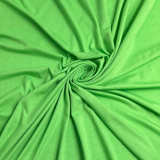 Bright green fabric draped in a spiral pattern, showing its smooth texture and drape.