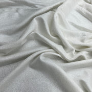 A close-up of draped white French terry with a subtle sheen and soft folds filling the frame.