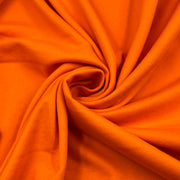 Bright orange fabric draped in a spiral swirl pattern, showing its smooth texture and soft folds.