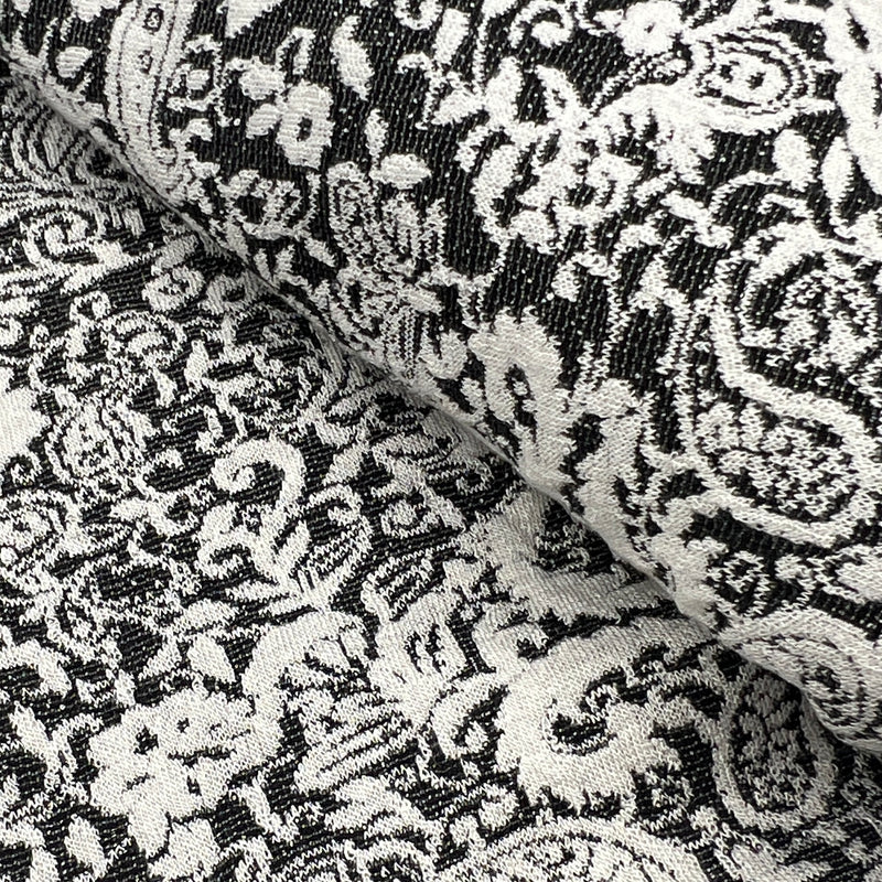 Black and white damask patterned fabric with a textured woven surface, shown in a close-up folded view.