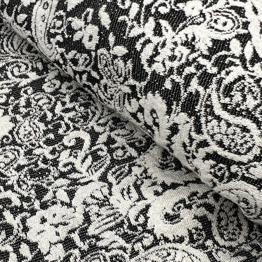 Black and white damask patterned fabric with a textured woven surface, shown in a close-up folded view.