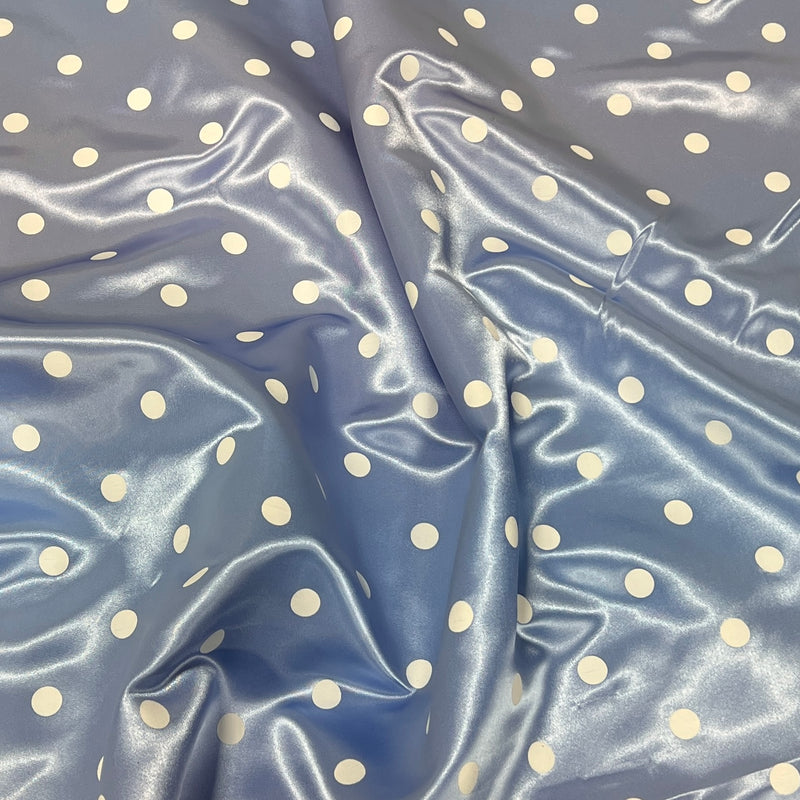 Light blue satin fabric with a white polka dot pattern, shown with soft folds and a glossy sheen.