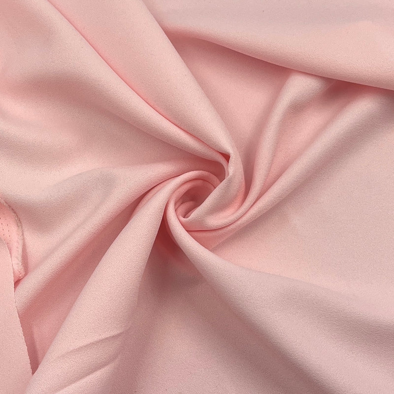 Pink textured polyester crepe fabric pulled into a swirl showing off smooth and elegant drape.