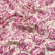 A close-up of draped fabric featuring a repeating pink rose print on a warm off-white background.
