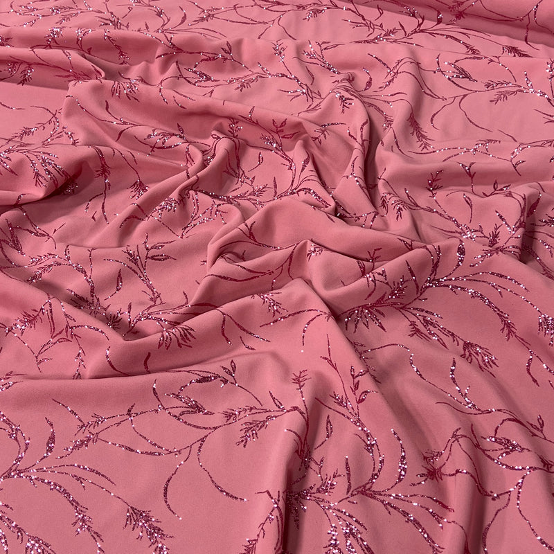 Dusty pink fabric with a delicate, repeating sequined floral vine pattern draped in soft folds.