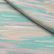 A close-up of a draped fabric with a textured, woven pattern featuring horizontal brushstroke-like bands of mint green, dusty pink, pale blue, and cream.